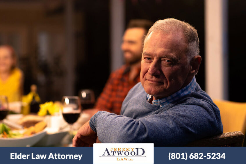 Elder grandfather at table with family. When to hire a elder law attorney
