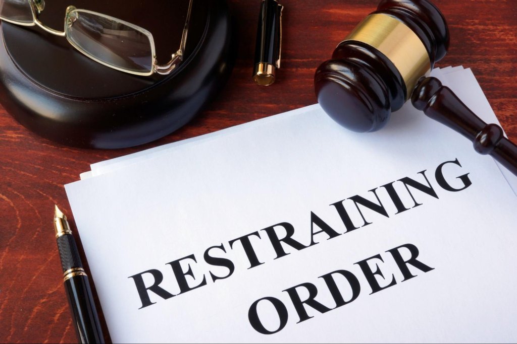 Restraining order document and gavel representing legal action for harassment protection.